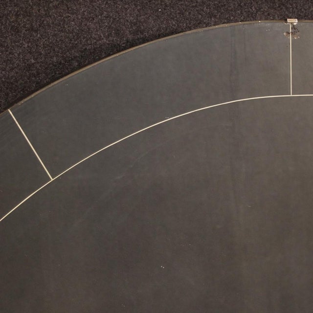 Italian mirror from the mid-20th century. A half-moon-shaped furniture with a wooden frame supporting the mirror, adorned...