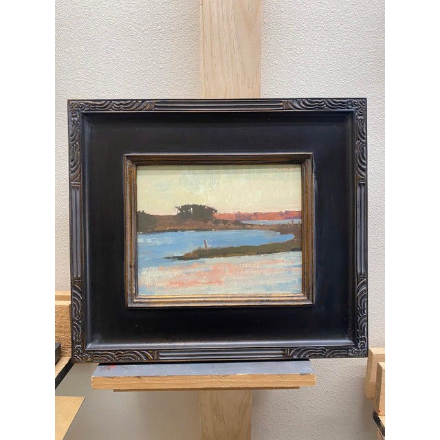 This oil on panel artwork captures a serene island landscape at sunset, with soft hues of pink and orange reflecting on...