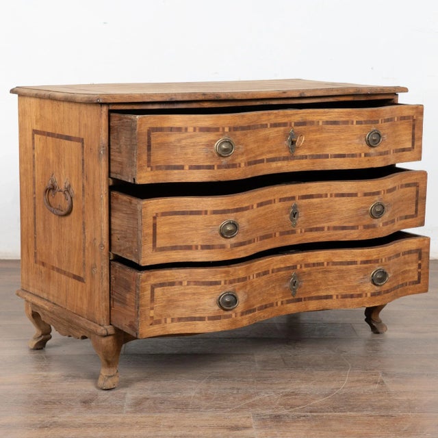 This antique rococo large oak chest of drawers is accented with contrasting inlaid trim along the top, sides and three...