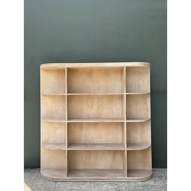 Defined by expansive proportions and soft architectural curves, this vintage solid oak étagère features a multi-tiered...