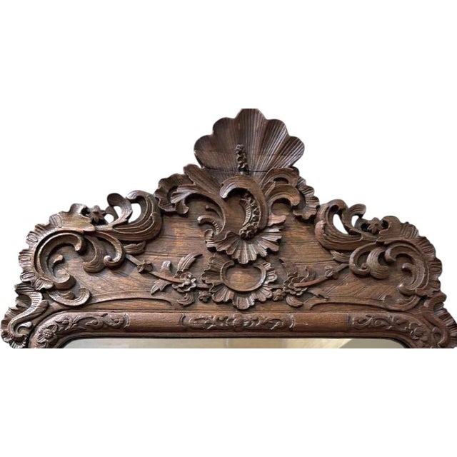 18th Century French Carved Oak Mirror. Mirror features deeply carved scrolling foliage, acanthus leaves, and floral motif,...