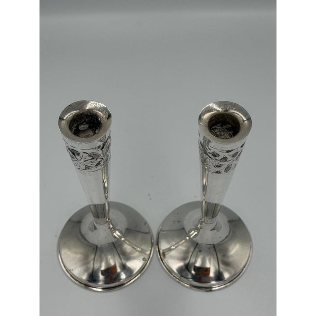 Elegant pair of early 20th-century sterling silver candlesticks, distinguished by their slender, elongated proportions and...