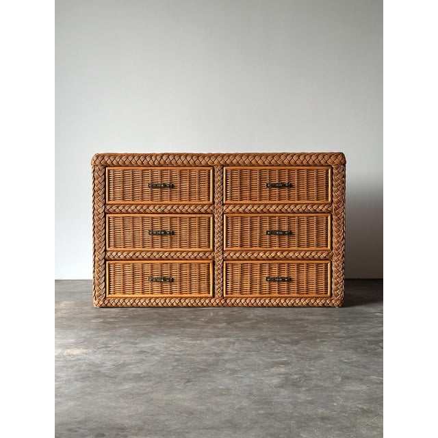 Fully wrapped in woven wicker, this vintage six-drawer dresser is finished with hand-braided rope trim outlining every...