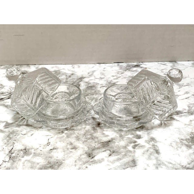 Set of two petite butter keeper containers with cut glass textured cloche dome covers and trays with flower pattern...