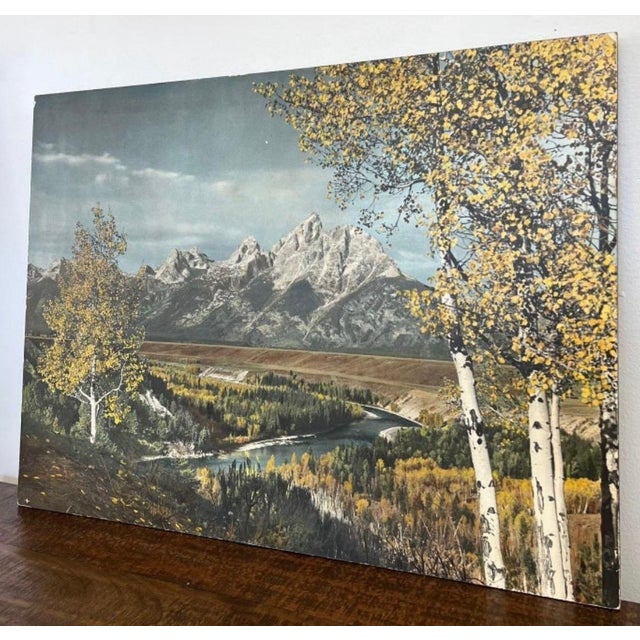 Large vintage landscape photographic print mounted on board depicting a mountain range with a river winding through a...