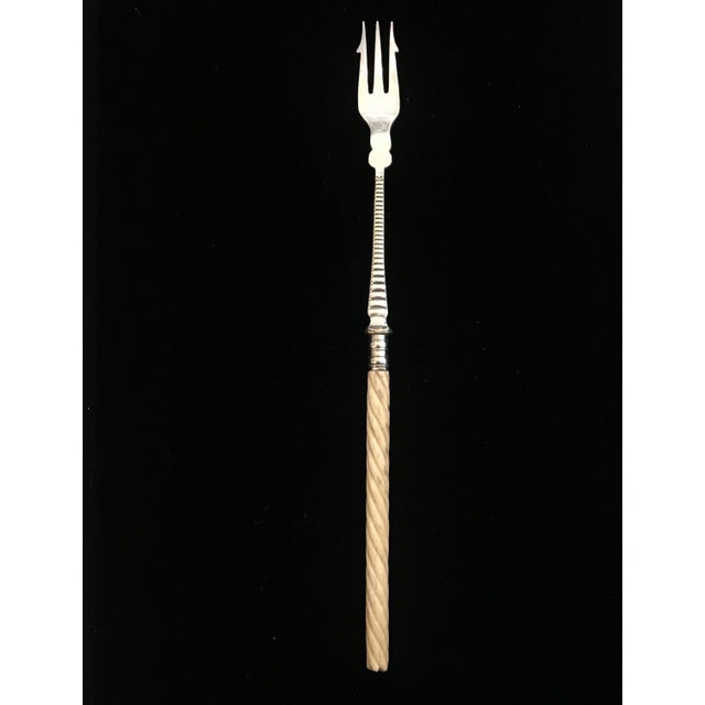 Antique British silver and bone pickle fork! This serving fork has smooth silver prongs, a textured silver neck, and a...