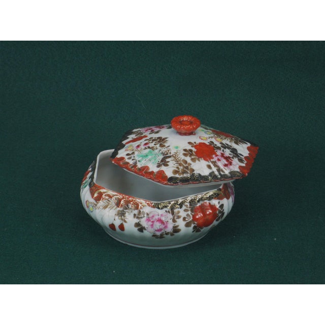 This is an antique Japanese Satsuma covered dish bowl and lid, made of porcelain and hand-painted in red and gold. It...