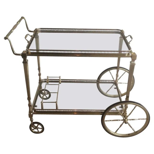 This neoclassical style bar cart is made of brass with removable glass trays. This is a French work by famous designer...