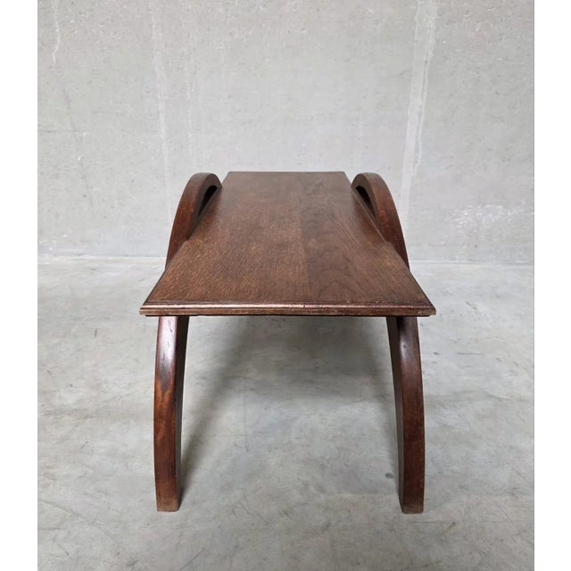 This sculptural and artisan made coffeetable from oak wood is defined by its curvilinear form.