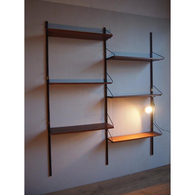 This wall mounted bookcase is made of teak, iron, and brass with a lamp from Stilnovo. Imprinted by Maker,This piece has...