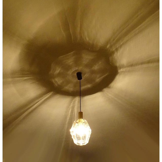 Large pendant light by limburg, featuring an oversized polyhedral glass shade with highlighted edge, polished brass...