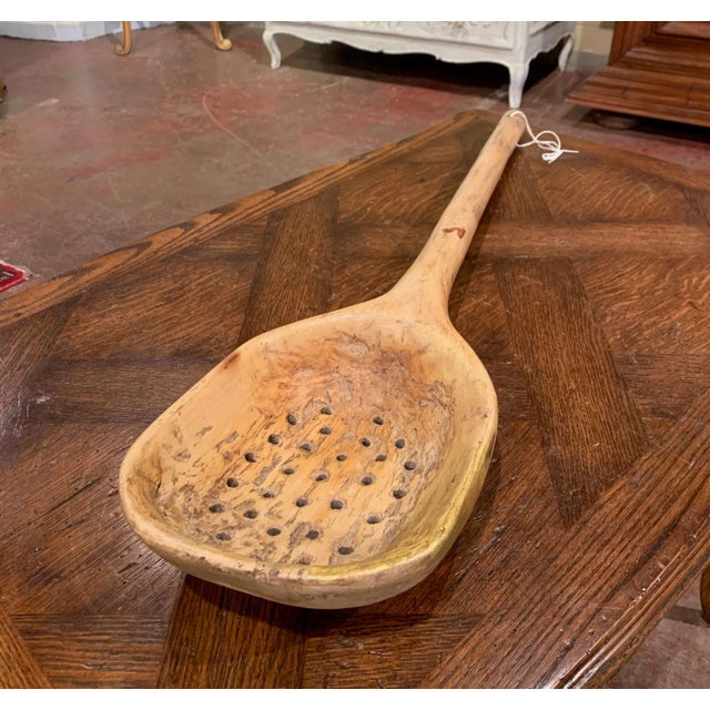 Decorate a kitchen wall with this large country spoon; carved in France circa 1880, the utensil with holes was used for...