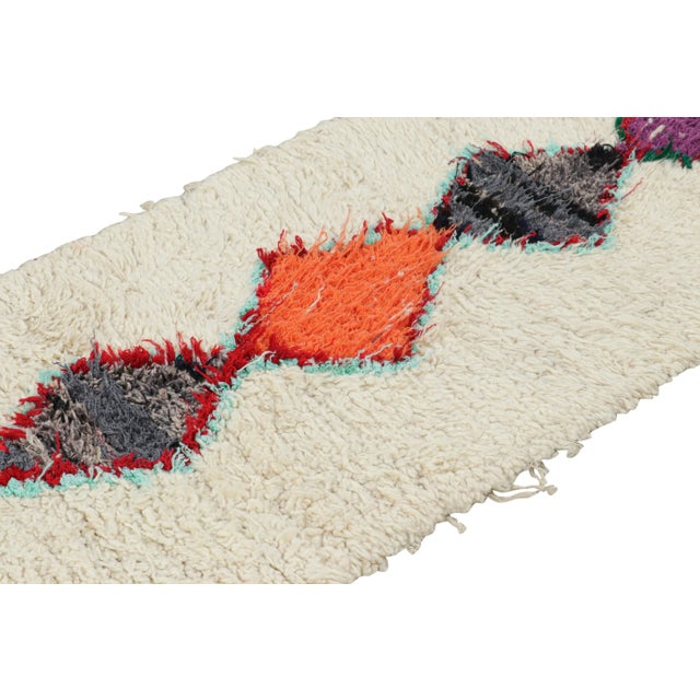 Hand-knotted in wool and originating from Morocco circa 1950-1960, this 2x6 vintage Moroccan rug is an extremely rare...