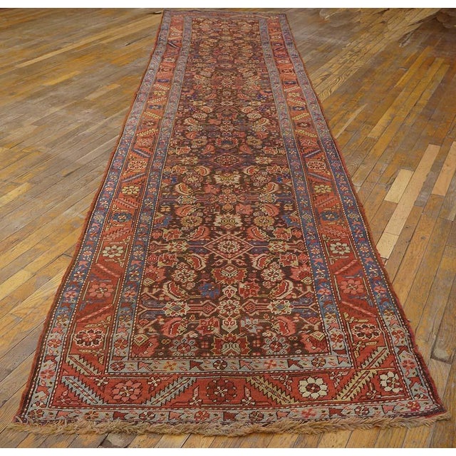 The somewhat corroded dark brown field of this wide Persian format kenare (runner) shows a Herati all-over design in low...