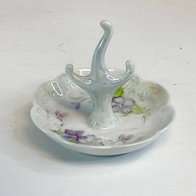 A lovely little porcelain ring dish. It’s from the early 20th century and is hand-painted with various shades of purple...