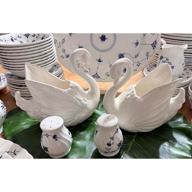 A pair of vintage white glazed ceramic swan planters featuring textured feather details and curved necks. The perfect...