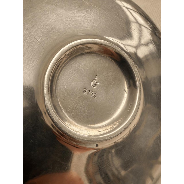A striking vintage decanter combining sculptural form with tactile materials. The fluid, teardrop-shaped metal body...