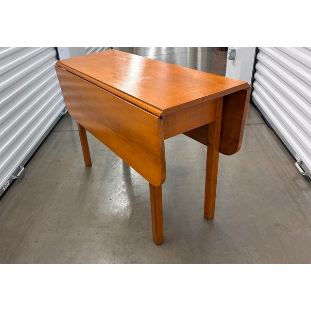 An 18th-century George III mahogany drop-leaf gate leg table is a masterpiece of classic British Cabinetry, balancing...