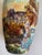 The vase depicts a French countryside landscape with a classic chateau surrounded by trees under a beautiful blue sky. The...
