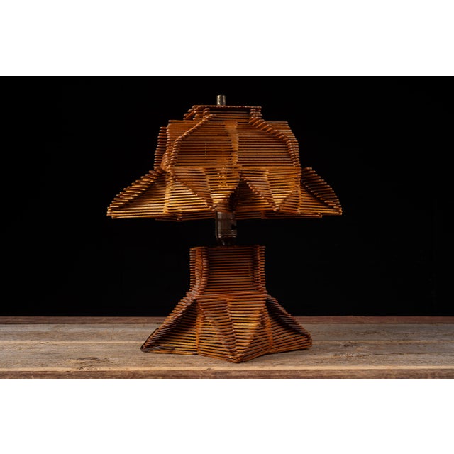 Mid-century handcrafted tramp art table lamp constructed from stained wood craft sticks arranged in repeating layered...