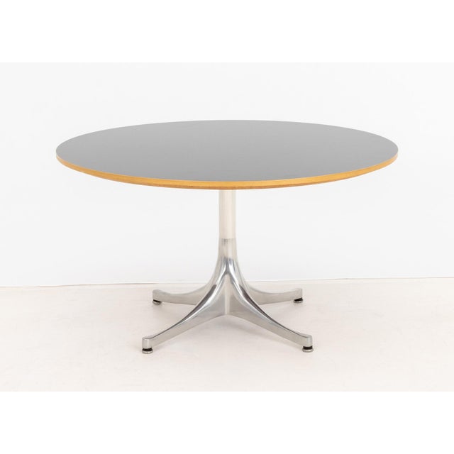 George Nelson for Herman Miller Pedestal Table, black veneered maple top above aluminum base, Herman Miller label to...