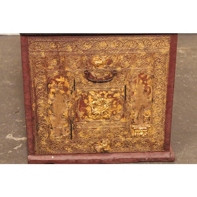 A richly decorated Burmese storage chest from the early 20th century. This antique trunk exemplifies the elaborate...