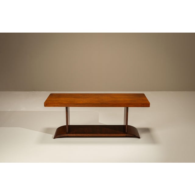 A restrained silhouette combined with warm mahogany veneer gives this coffee table a quiet architectural presence....
