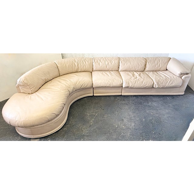 This vintage 1980s Weiman attributed sectional sofa features plush beige leather upholstery and a curved modular design....