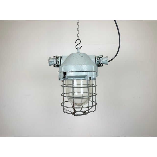 Industrial factory hanging light manufactured by Elektrosvit in former Czechoslovakia during the 1970s. It features a cast...