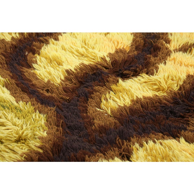 Hand-knotted in lush, high-pile wool in Sweden circa 1960-1970, this 4x6 vintage Swedish Rya rug is a bold new addition to...