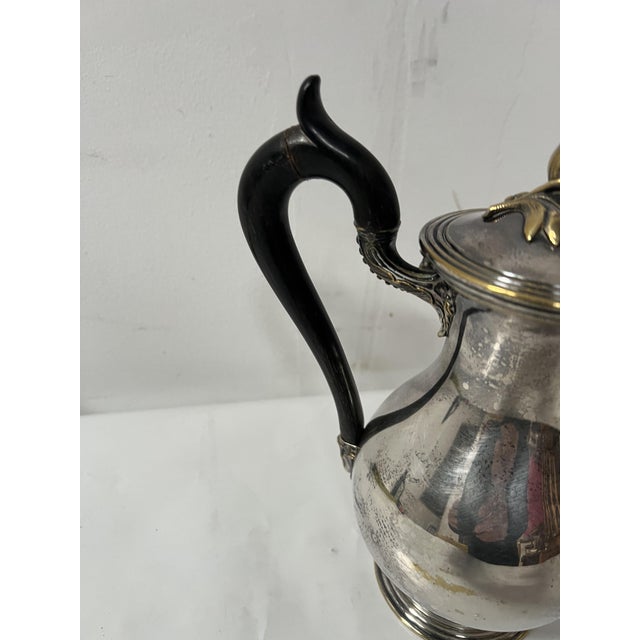 Silver-plated metal teapot by cristofle ebony wood handle lid decorated with foliage and pine cones wear to the silver...