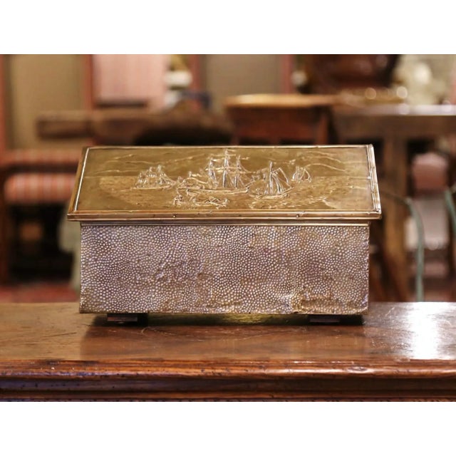 Crafted in France, circa 1920, the antique wood and brass coffer stands on wooden feet, the slant top opens up and reveals...