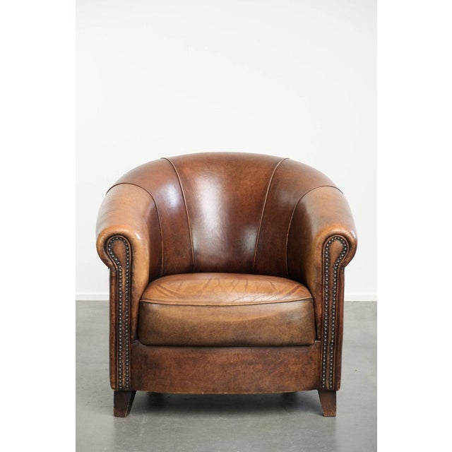 This beautiful English-style sheepskin club chair in gorgeous cognac tones features a fixed seat cushion, is finished with...