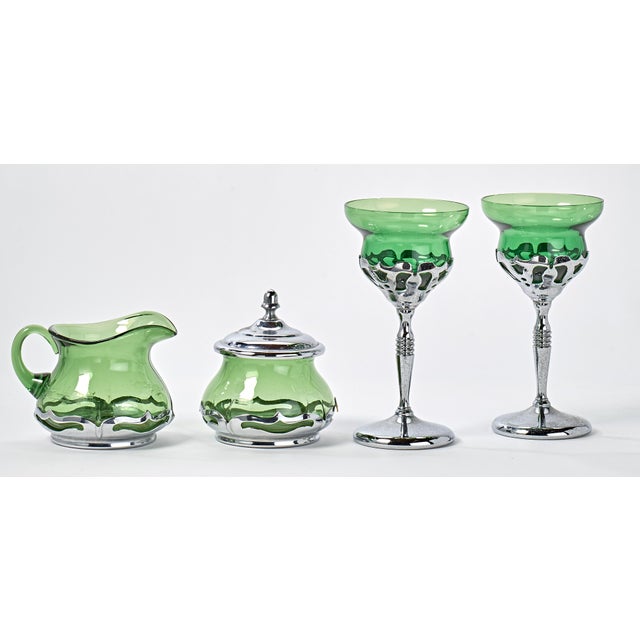 Set includes a creamer, sugar dish and two stemmed glasses. Nice vibrant green, very similar to depression ware.