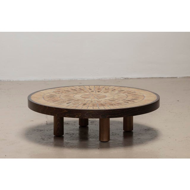 Round coffee table designed by Roger Capron in France around 1970. This table features a solid wooden frame and a table...