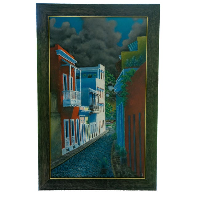 Oil on canvas, signed "Nico," late 20th century. Colorful street scene with colonial-style buildings under a dramatic sky....