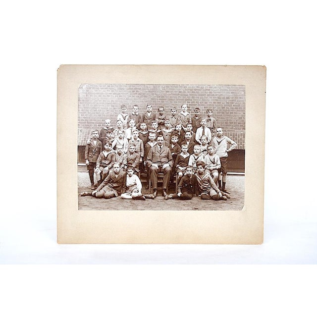 Captured in sepia tones, this class of boys stare confidently into the camera with the hint of smiles on their young...