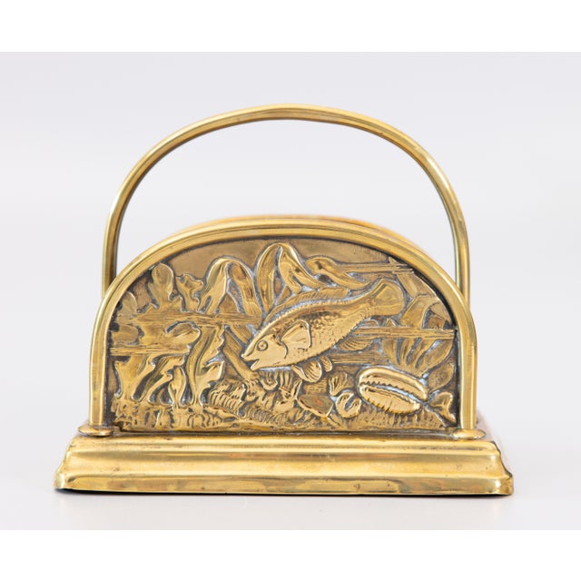 A superb English Edwardian repoussé brass letter rack, circa 1930. It has a charming fish and stylized foliate design with...