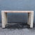 This postmodern console table pairs polished tessellated stone with a refined architectural silhouette. Ivory tiles with...