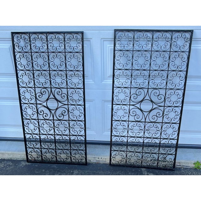 Antique Black worught iron gates with two side panels. The original swing gate hardware is still attached and the band to...