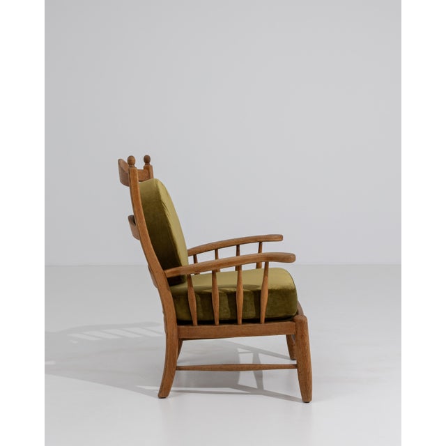 A distinctive Brutalist armchair emphasizing solid construction and bold, angular lines. The oak frame showcases...