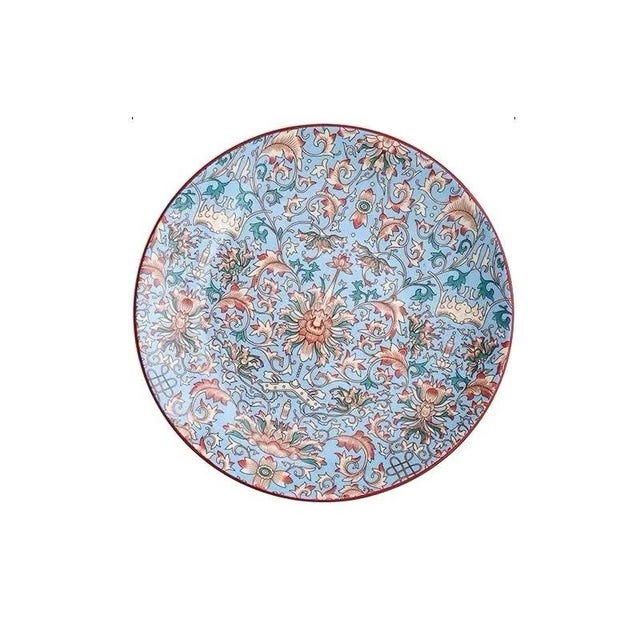 Employing the hand-painted famille rose technique, the plate is fully decorated with intertwined floral patterns,...