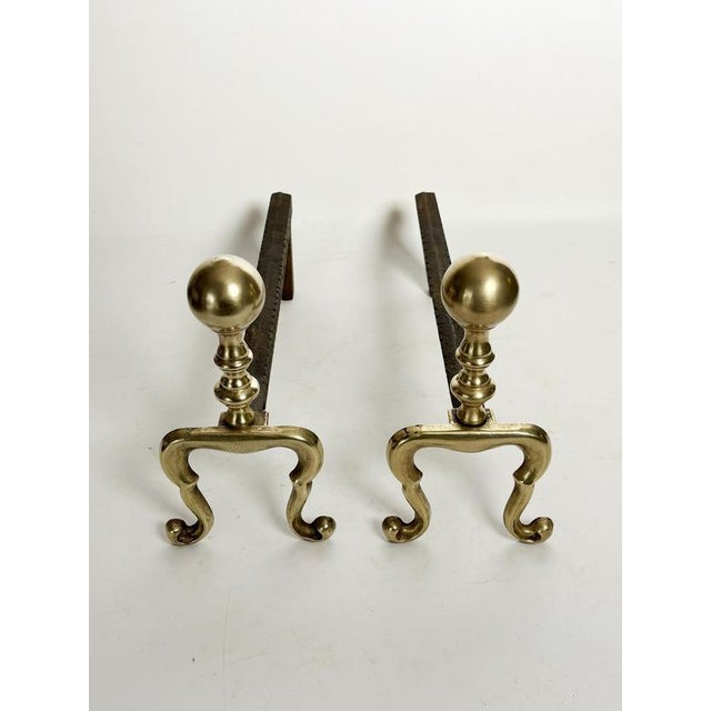 An elegant pair of French andirons dating from the 1950s, combining cast iron and brass. These andirons are distinguished...