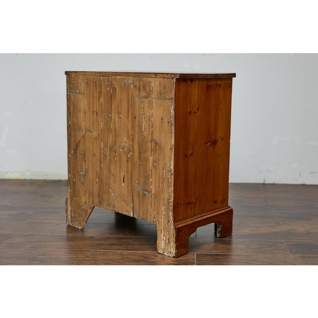 An English pine chest from the 19th century with three graduating drawers and brass hardware. This English pine chest from...