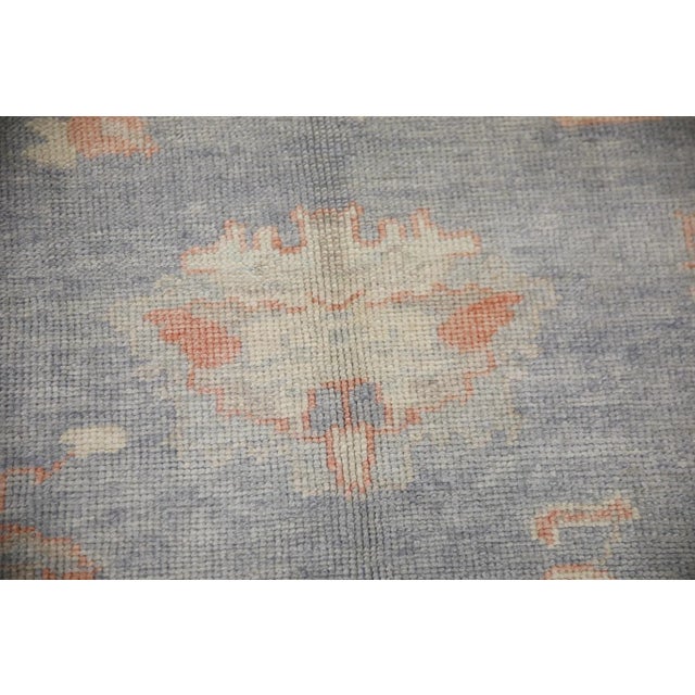 This modern Turkish Oushak rug is a stunning piece of art that has been handwoven using traditional techniques by skilled...