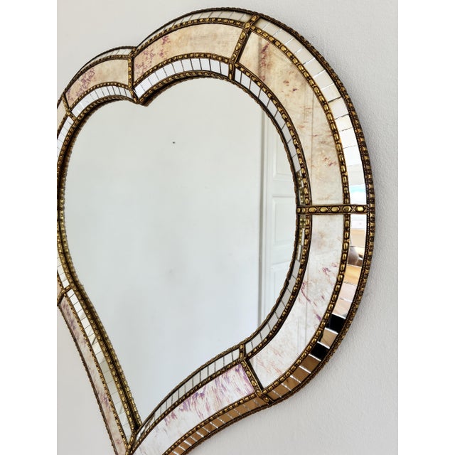 A large vintage Spanish Venetian-style hearth-shaped beveled wall mirror, dating to the 1980s. The mirror has a decorative...