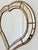 A large vintage Spanish Venetian-style hearth-shaped beveled wall mirror, dating to the 1980s. The mirror has a decorative...