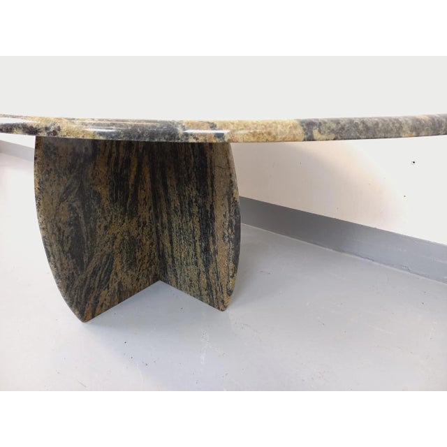 Vintage coffee table from the 1970s, with a double-pointed or oval top and a four-sided central leg. Made of marble in...