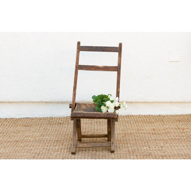 Antique folding ladderback chair, a rustic relic of the past: This antique folding ladderback chair, with its weathered...