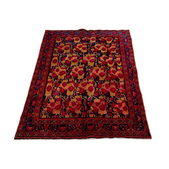 This hand-knotted Persian wool rug has a dark blue field with accents in red and brown all over the floral design. This...